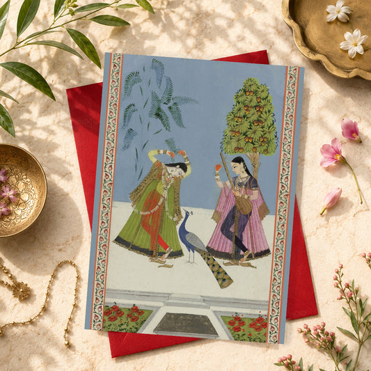A large Indian art greeting card featuring Two Women and a Peacock (Gujara Ragini), ca. 1780.
Two elegantly dressed women stand beneath trees in this beautifully poised scene: one tunes a tanpura beneath a fruit-bearing mango tree, while the other reaches towards a branch and looks towards the peacock nearby.