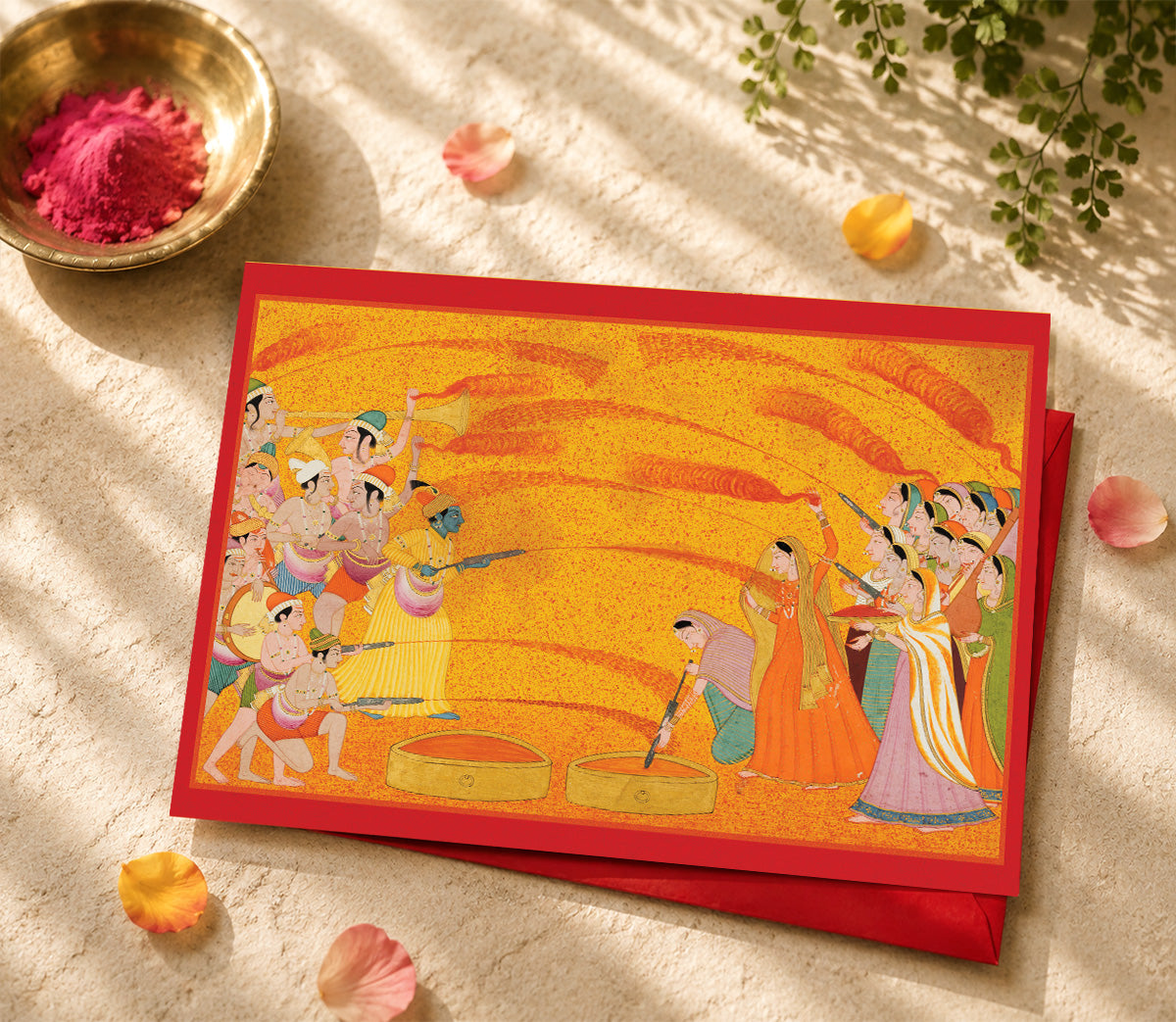 A large Indian art greeting card featuring Krishna Celebrates Holi, c. 1770.
Against a brilliant field of yellow and red, Krishna and his companions celebrate Holi in a joyous burst of music, movement and colour. Streams of coloured water arc across the scene as the two groups playfully spray one another with pichkaris — traditional water syringes used during the festival.