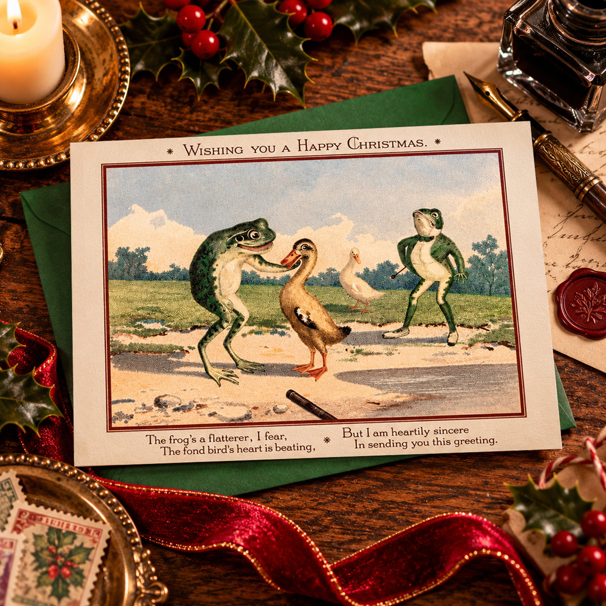 A vintage-style "weird Victorian" Christmas greeting card laid on a wooden table, surrounded by holiday props including a candle, holly, red ribbon, ink bottle, and wax seal. The card shows an illustrated scene of two frogs and a duck, with the text 'Wishing you a Happy Christmas." and the short poem starting with "the frog's a flatterer, I fear" 